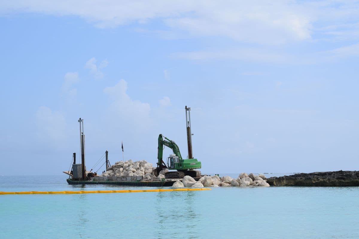 Excavator and crane on a construction barge, Nassau harbour, New Providence