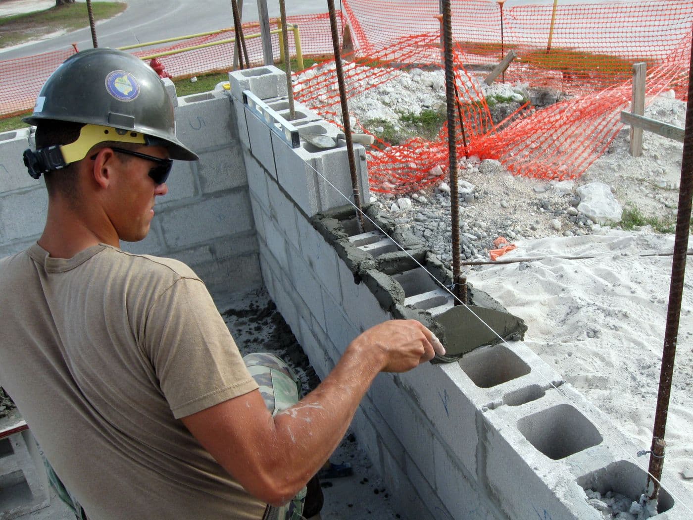 Mason laying concrete block with mortar, Andros